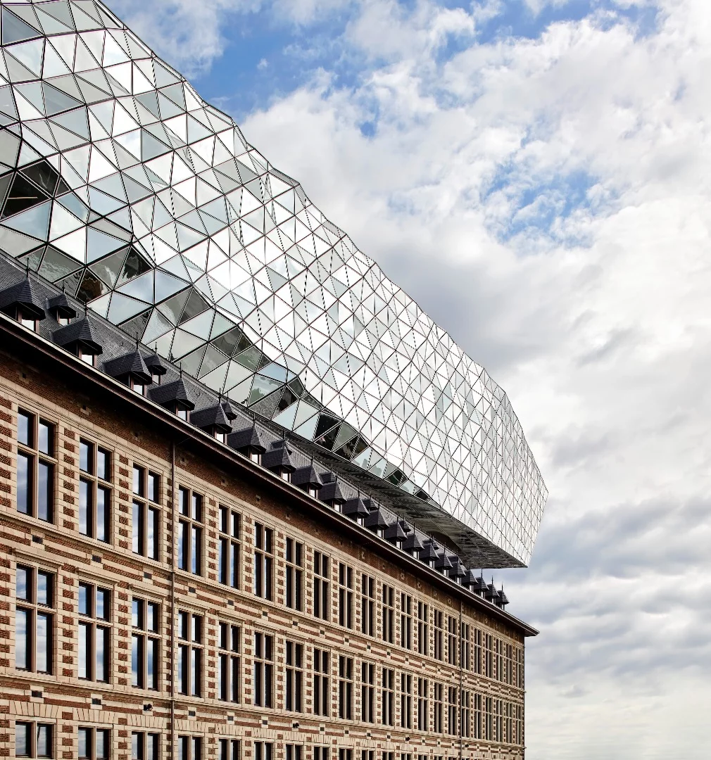 Its facade comprises triangular glass facets, some of which are transparent, while others are opaque