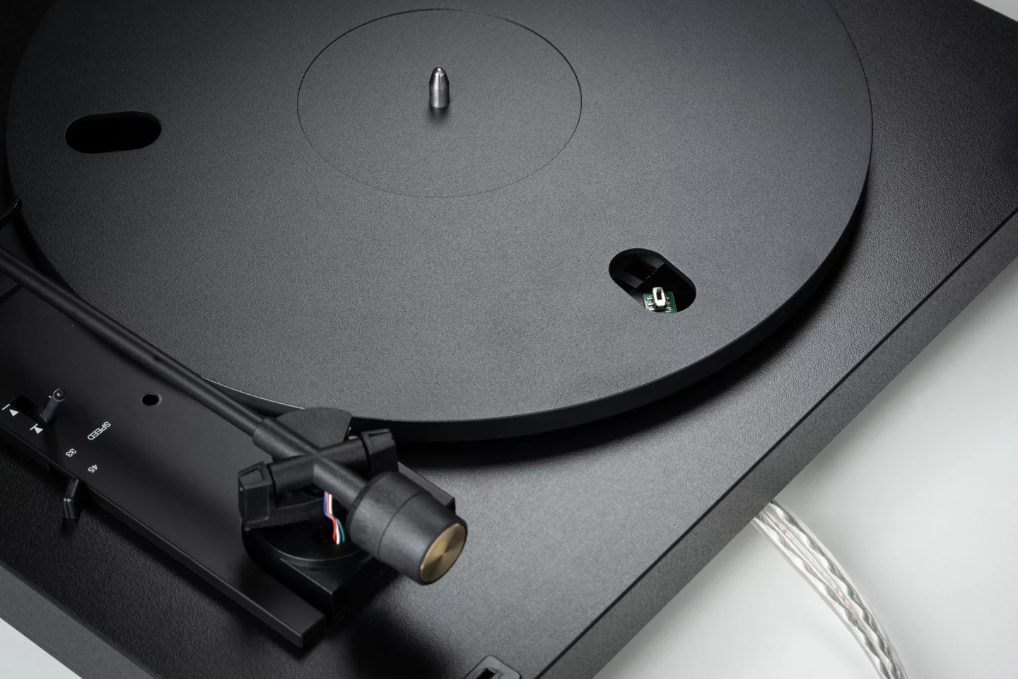 The A1.2 turntable features an aluminum tonearm with carbon-fiber headshell and moving-magnet cartridge, a belt-drive platter mounted in a dampened wooden chassis, and mechanical automatics