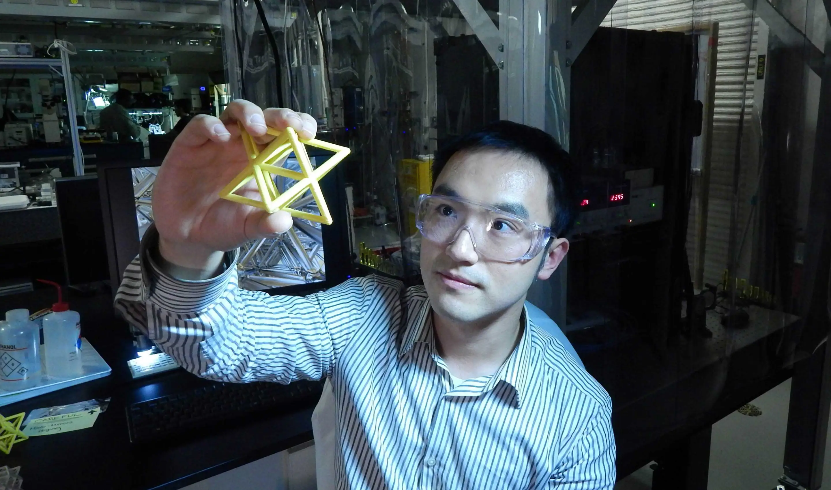 Lawrence Livermore Engineer Xiaoyu "Rayne" Zheng studies a macroscale version of the unit cell that makes up the the ultralight, ultrastiff material (Image: Julie Russell/LLNL)