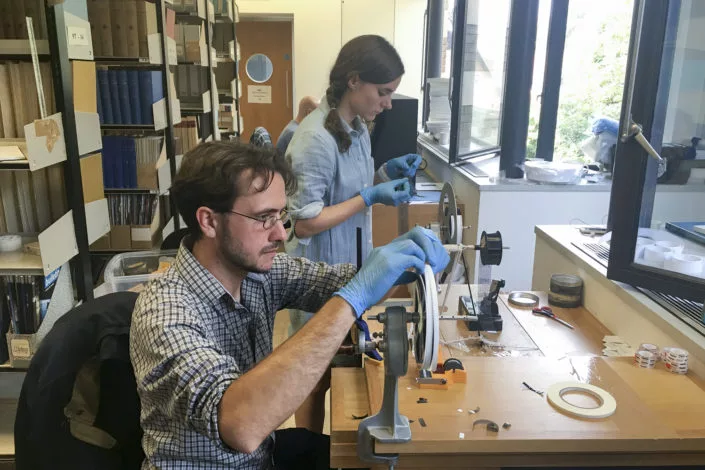 Dustin Schroeder (front) and art historian Jessica Daniel, preparing the film for digitization