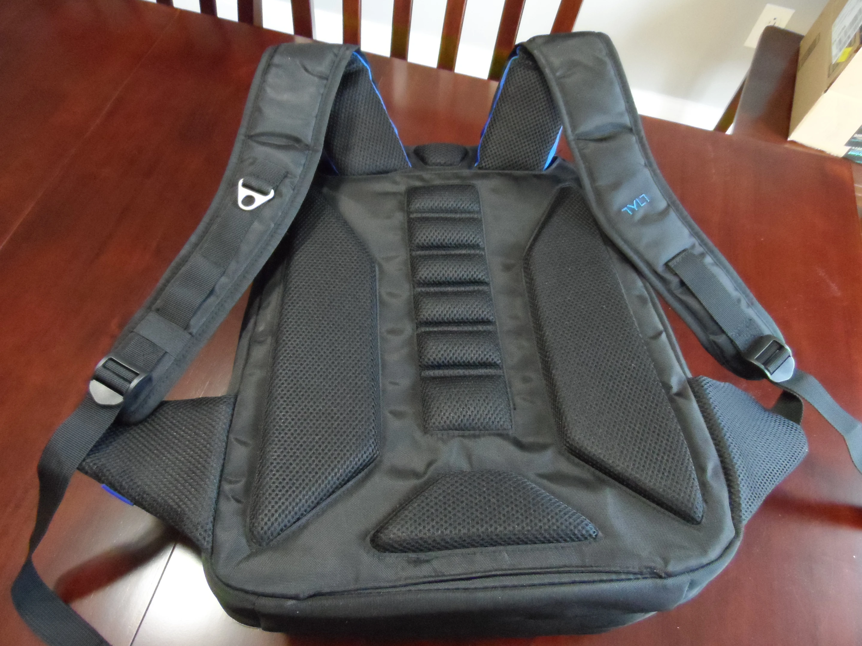 The backpack features a pass-through on the back for carrying on top of wheeled luggage