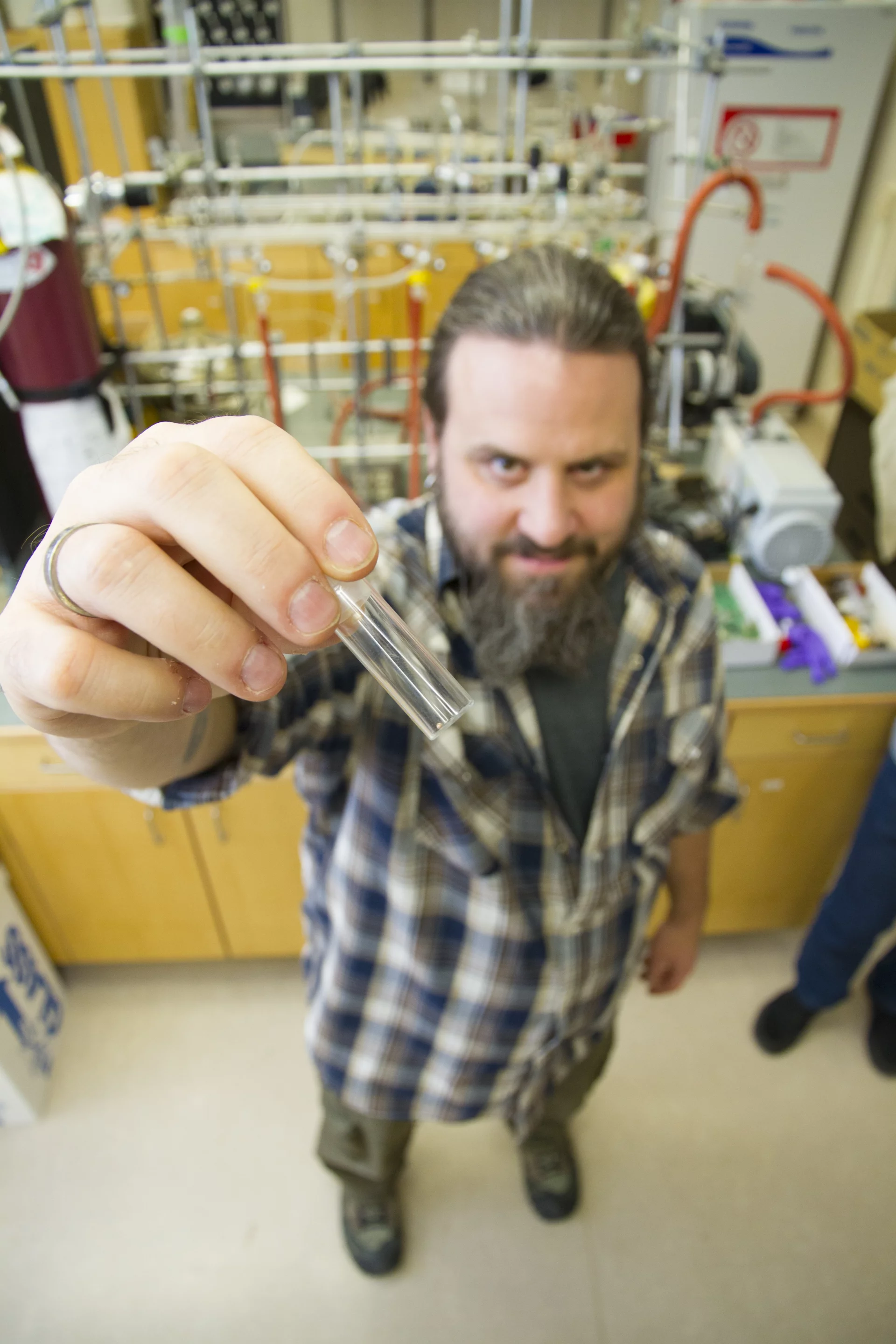 Stephen Foley holds a vial of the environmentally-friendly solution that his team has developed to extract gold from scrap electronics