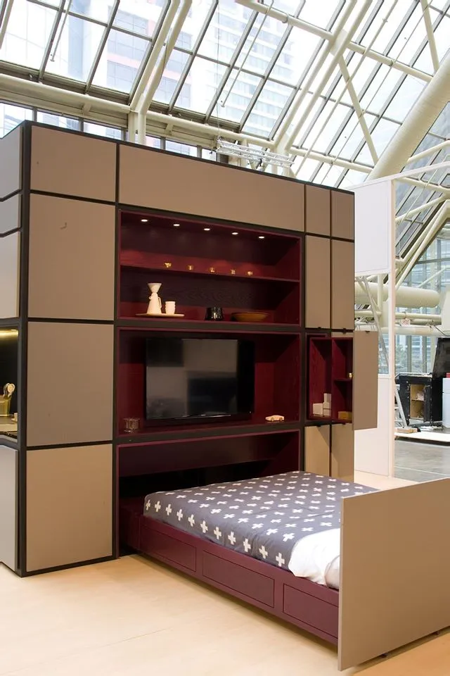 Adjacent to the kitchen is the entertaining lounge wall, equipped with flat screen TV, integrated book shelves, further storage space and a hidden double bed which slides out from underneath the cabinet