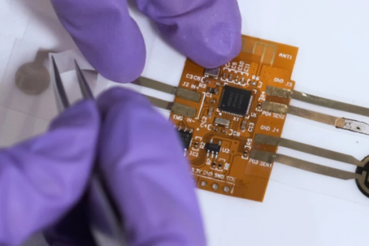 BIND connectors (gold ribbons), being applied to a printed circuit board