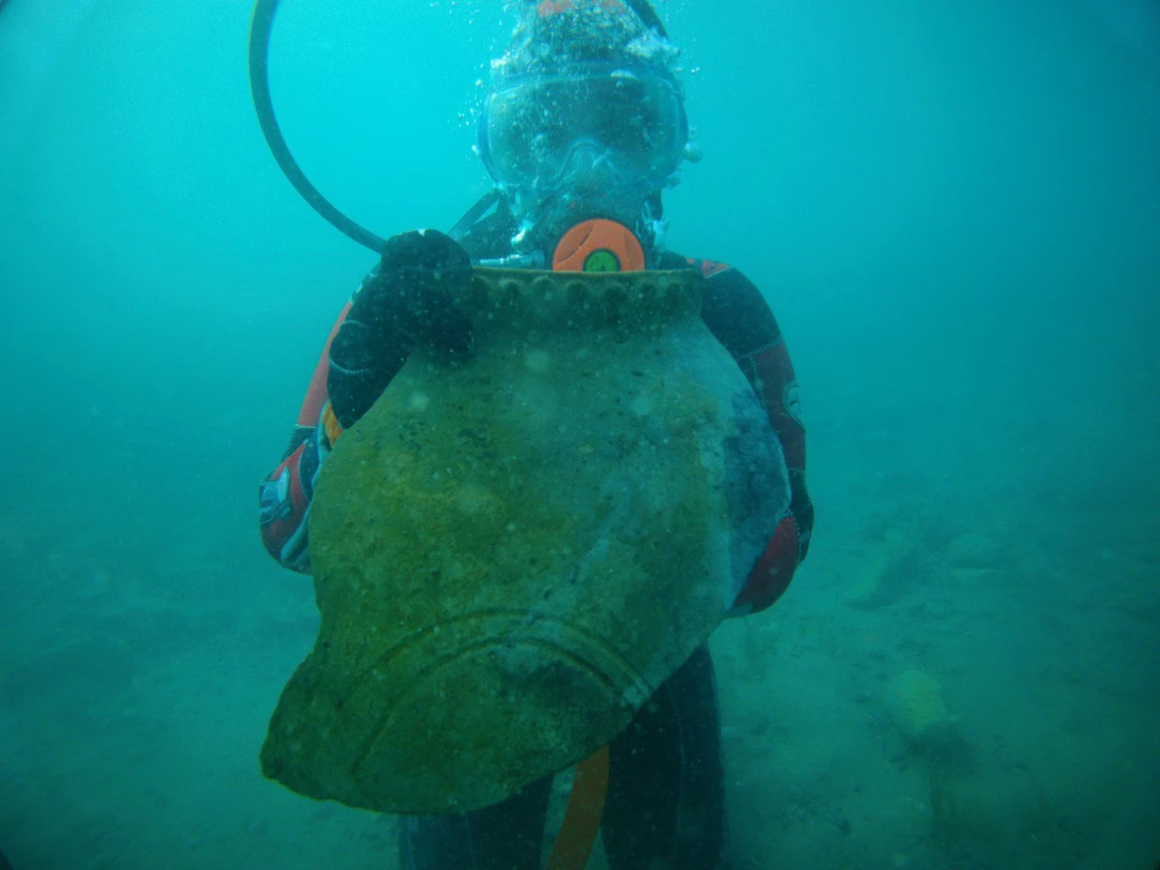 Kristina Guseynova, a laboratory assistant at the Institute of Archaeology of the Russian Academy of Sciences, with a part of an ancient jug