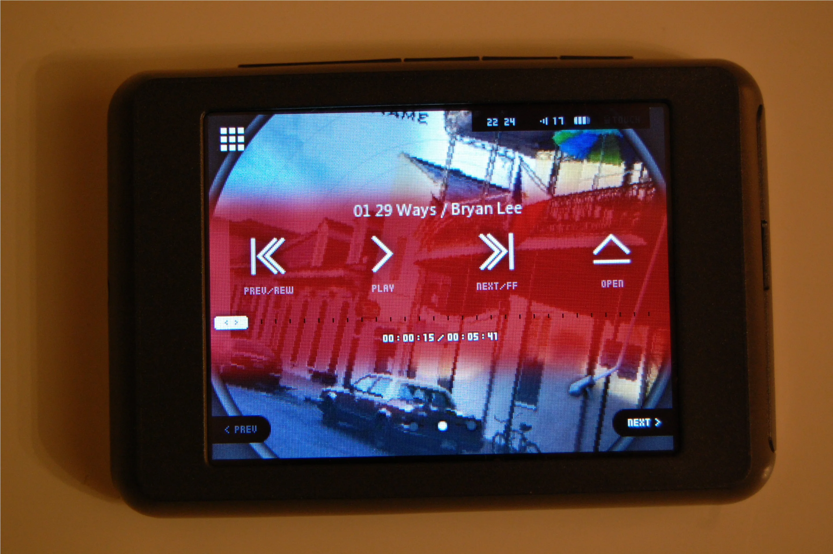 Tapping anywhere on the screen brings up the main playback menu, featuring icons resembling those found on a CD player