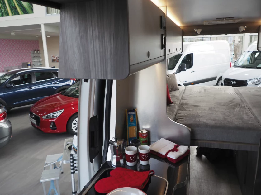The kitchen area includes a sink, dual-burner stove and refrigerator