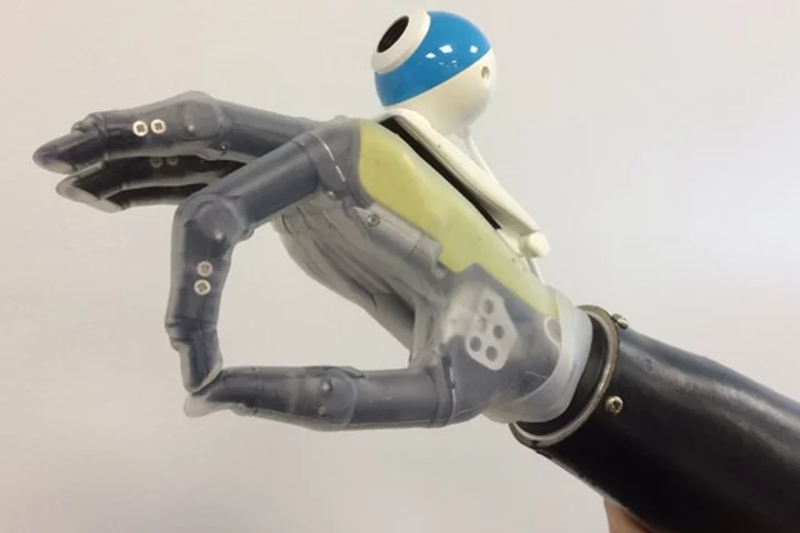 The prototype hand uses an off-the-shelf digital camera to help reach for and grasp objects