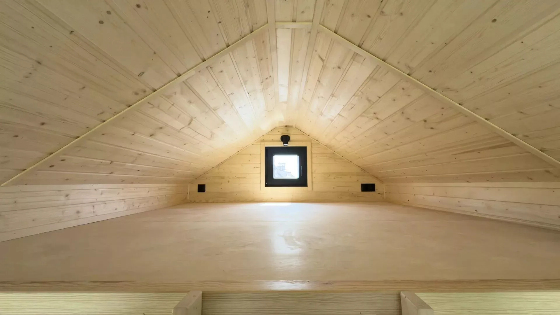 Above the kitchen and bathroom is a mezzanine sleeping area sporting a low ceiling and single small window