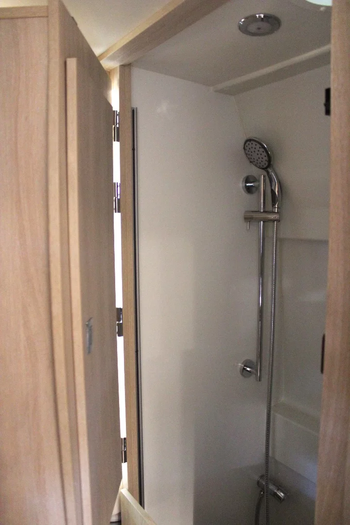 When it's time for a shower, the wardrobe swings around over the bed to clear out the shower room
