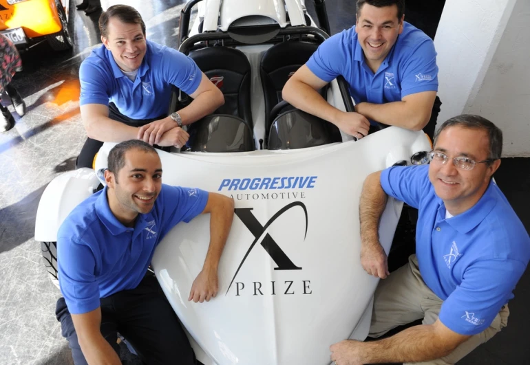 Team OptaMotive members (clockwise from top right: Mark Demers, Mike Nispel, Murat Ozkan and Michael Worry) with their E-Rex electric vehicle which has qualified for the next round in the Progressive Insurance Automotive X Prize competition