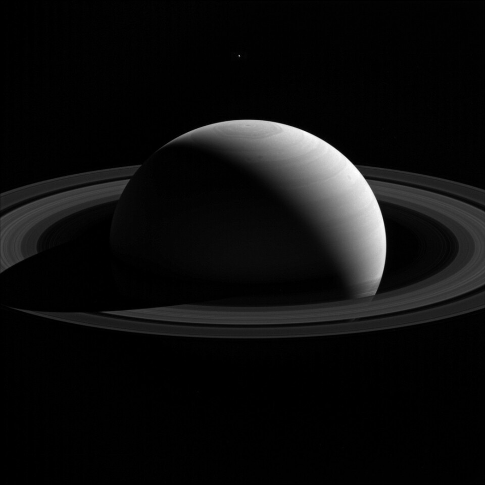 Tethys floats above the north pole of Saturn in a Cassini image from 2015