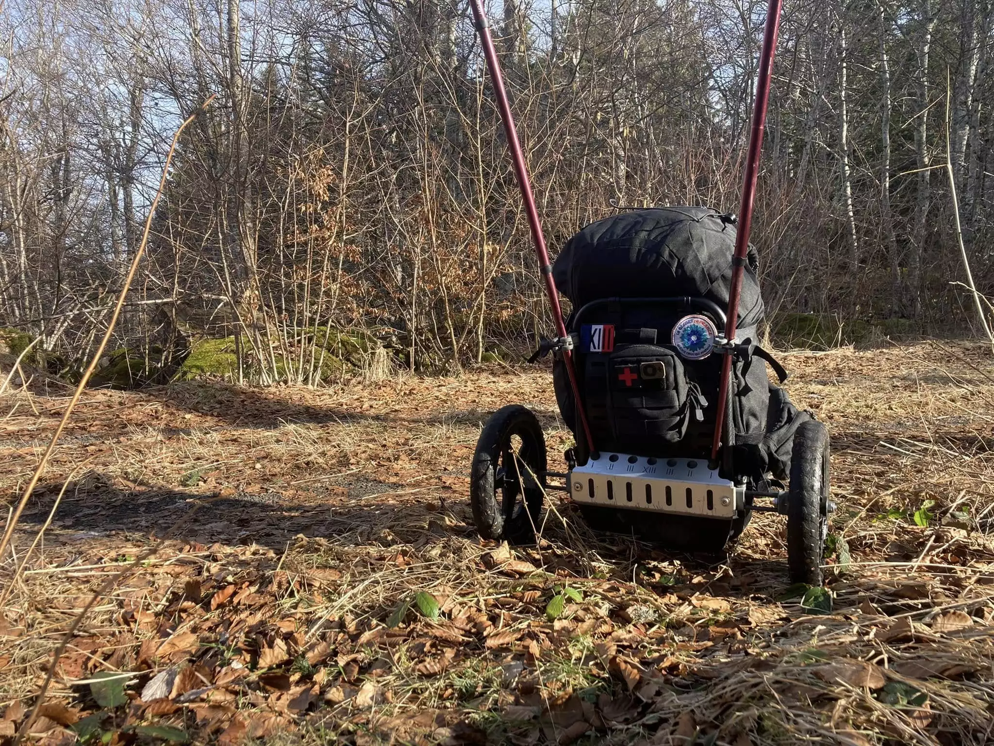 The hiker's poles secure via slots in the frame base and a pair of clamps, serving as the tow bar/handles