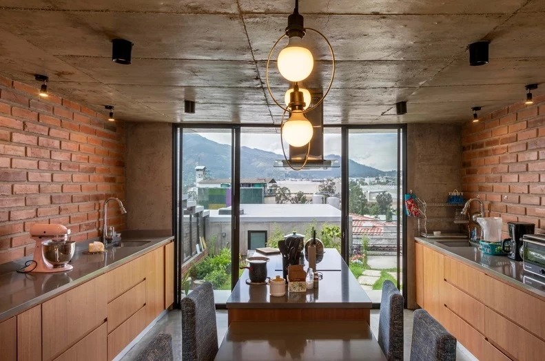 The second volume features a large modern kitchen with an additional open space for dinning and socializing