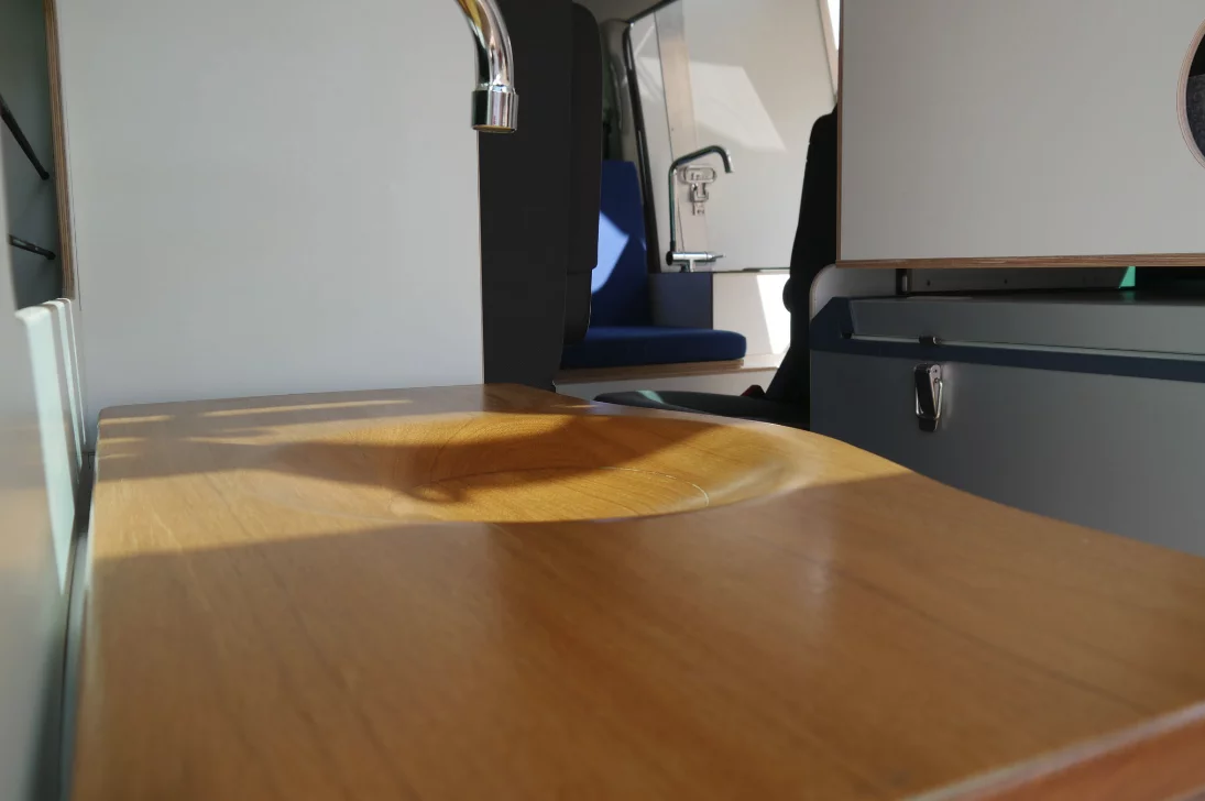 The wood basin just drains directly into the toilet for simplified plumbing