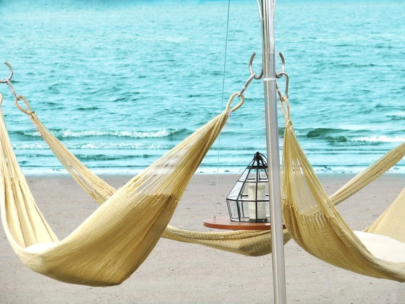 Each triple hammock structure also features a teak table hanging in the middle