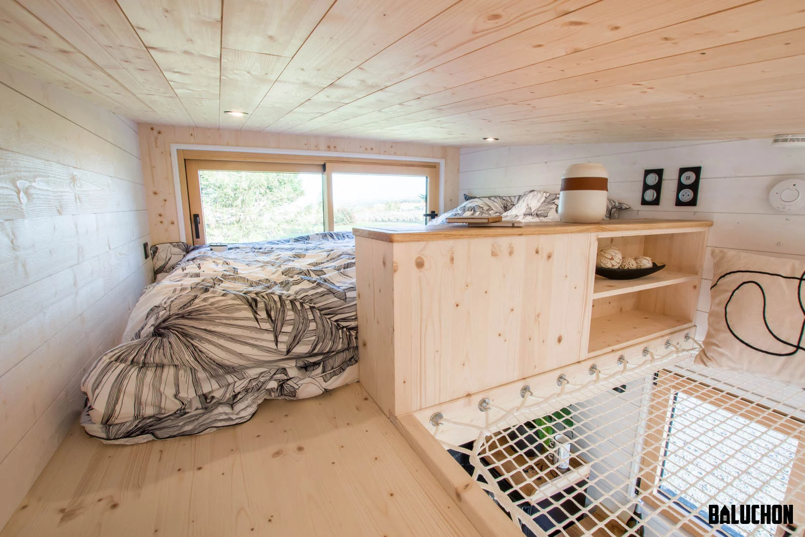 The Ræv's bedroom is a typical tiny house-style loft space with a low ceiling and a double bed