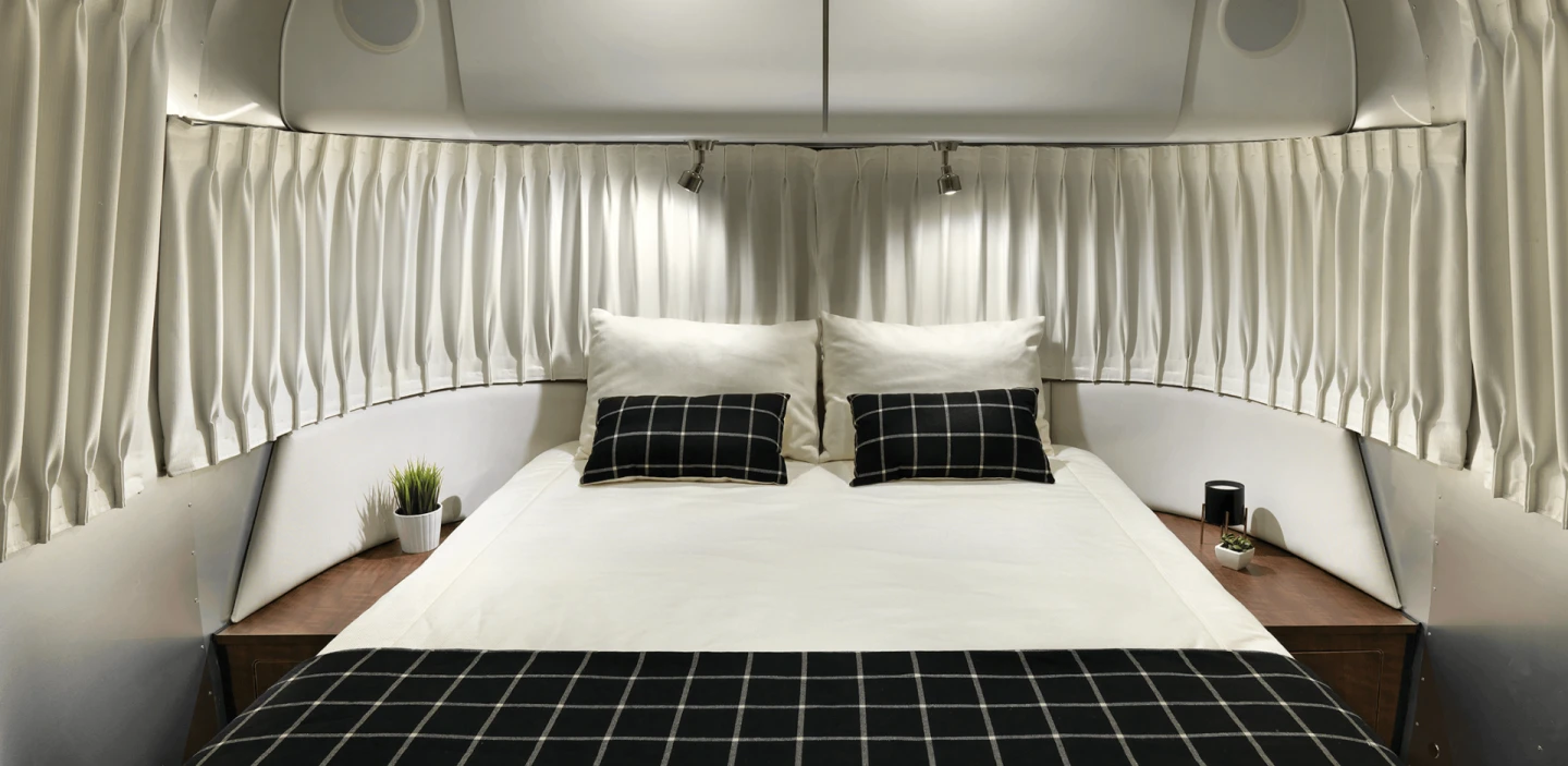 Made to sleep up to six people, the Airstream Globetrotter's bedroom features an adaptive foam mattress surrounding by curvy, low-profile panoramic windows
