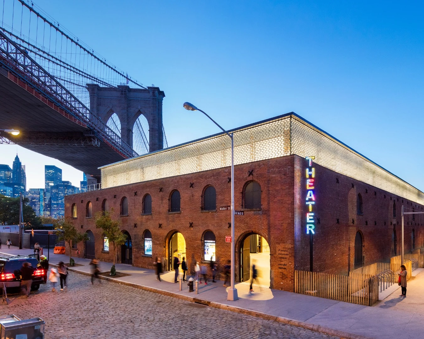 Outside St. Ann's Warehouse, a triangular garden designed by Michael Van Valkenburgh and enclosed by original masonry walls provides access to the lobby and gathering space before and after performances