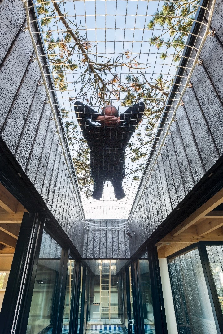 Treehouse features a net area above a small pond