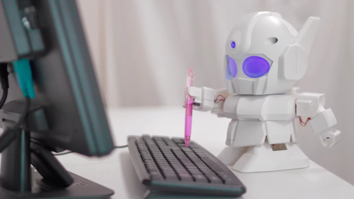 RAPIRO grabs a pen and types a message on a keyboard