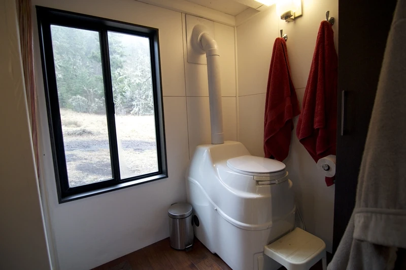The bathroom features a composting toilet