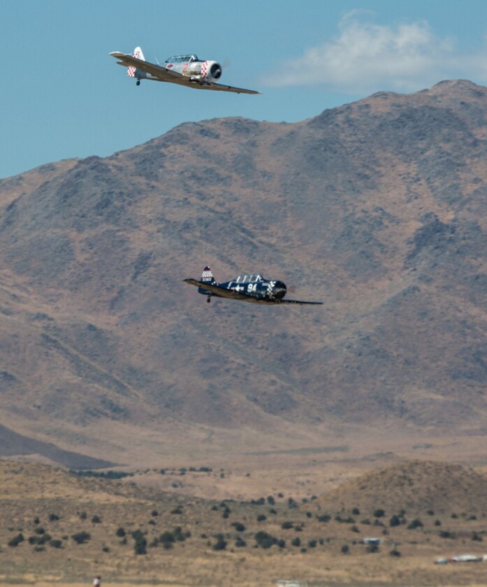Two T-6 planes with the spectacular, mountainous Reno landscape behind them