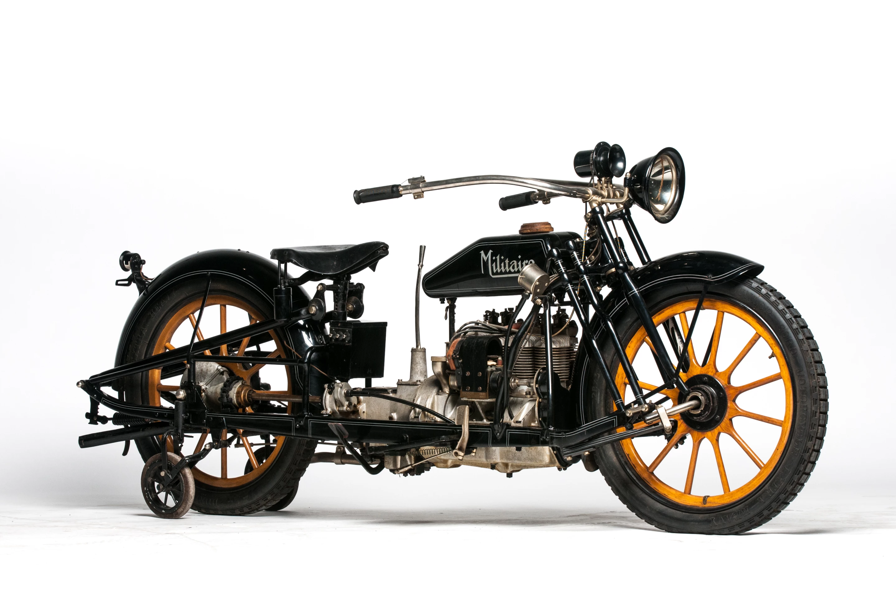 This 1915 Militaire Model 2 is a fascinating and unconventional four-cylinder motorcycle with an equally fascinating history as it was developed through several manufacturers. Now very collectible and extremely rare, the "two-wheeled car" features outrigger wheels which are operated by lever for low speeds, center-hub steering and wooden wheels.