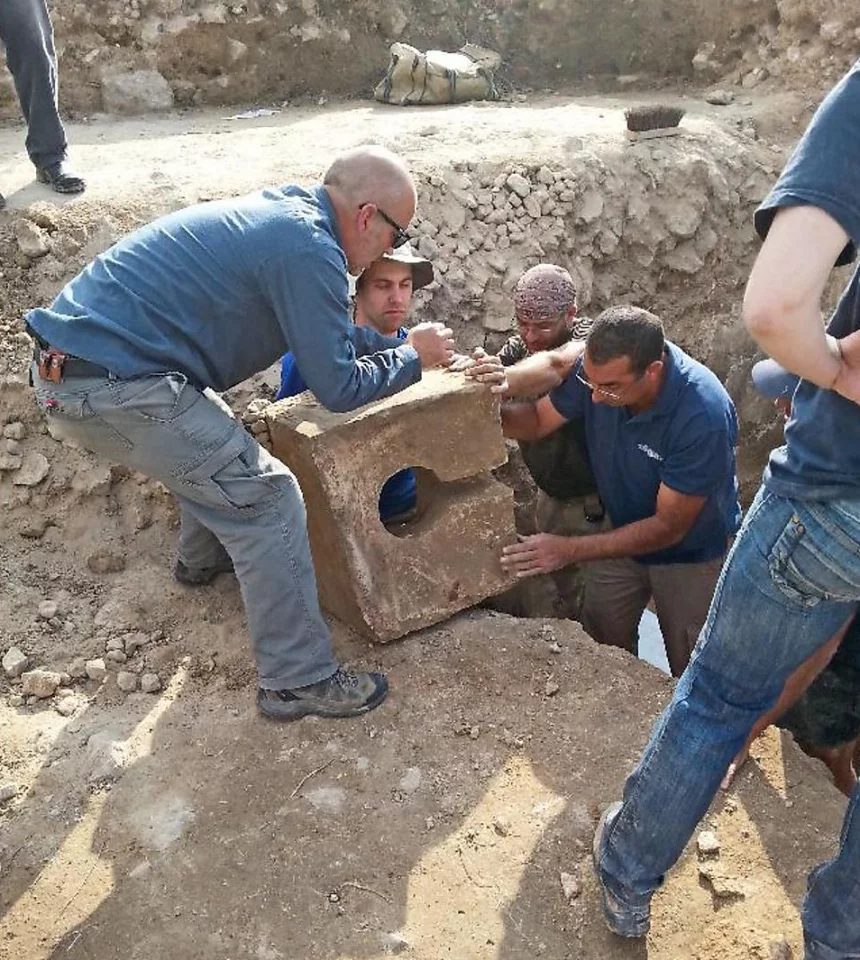 Archaeologists unearthing a stone toilet from a gate shrine at Tel Lachish, Israel