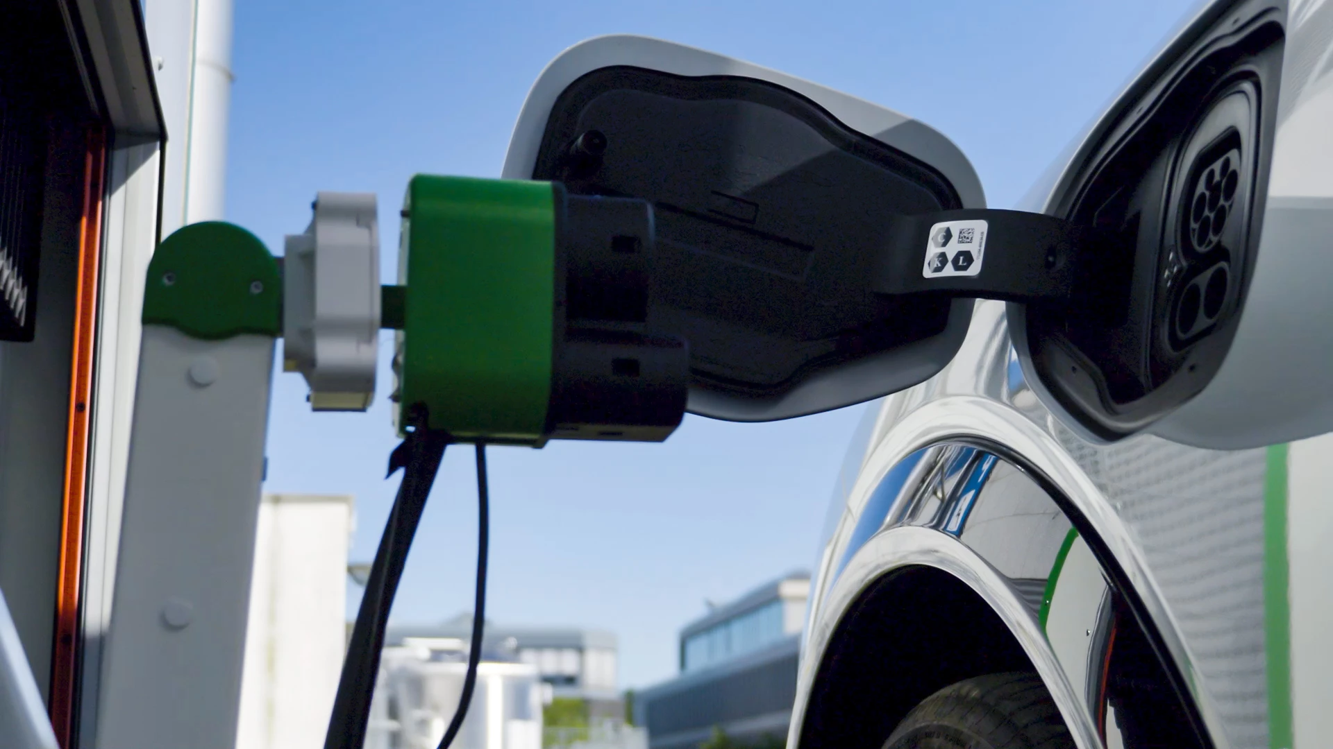 When the charging procedure is activated, a robotic arm moves out and locates the vehicle's charging port using a built-in camera, plugs in and starts charging