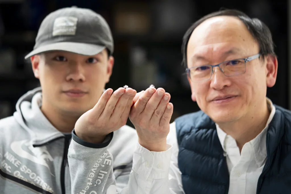 Co-first author of the study, grad student Wei Yue (left) poses with Prof. Liwei Lin (right) – along with a couple of the robots