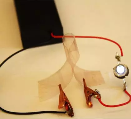 A new flexible film made of copper nanowires and plastic conducts electricity illuminating a small light bulb (Image: Ben Wiley, Duke University)