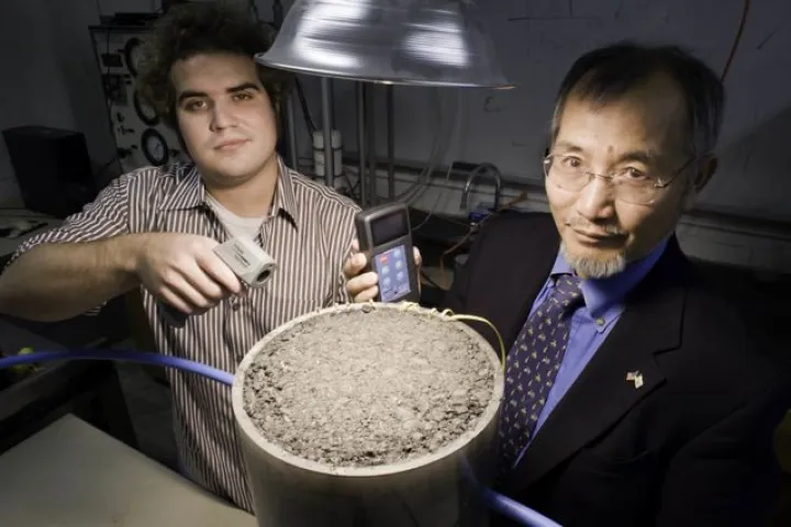 University of Rhode Island graduate student Andrew Correia (left) and Prof. K. Wayne Lee, measuring the solar energy generated by a patch of asphalt