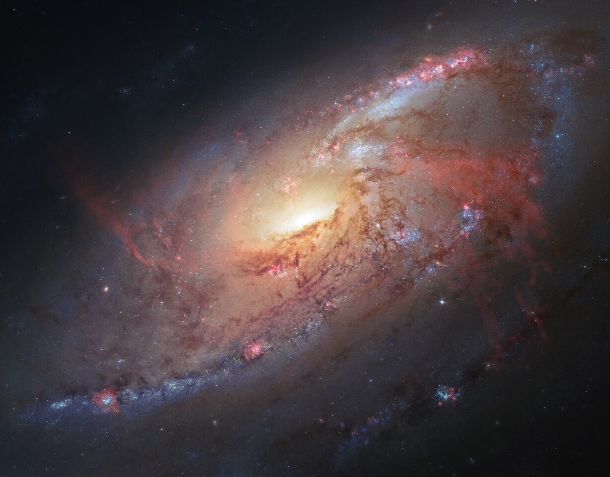 This image combines Hubble observations of M 106 with additional information captured by amateur astronomers Robert Gendler and Jay GaBany. Gendler combined Hubble data with his own observations to produce this stunning colour image