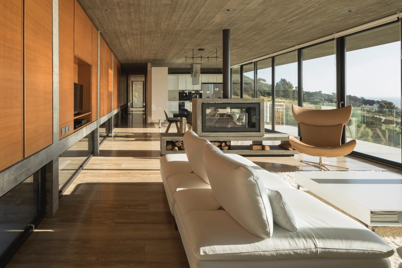 La Casa H is built into hills around the coastal town of Zapallar, leaning on a set of four reinforced concrete beams running the length of the structure