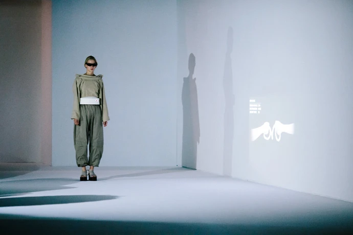 Models at Paris Fashion Week demonstrate the outfit, with their moods projected up on the wall