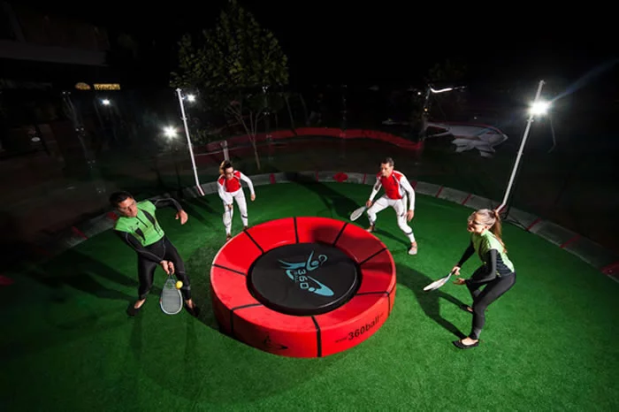 In the new racquet game of 360ball, players hit a ball into a central concave dish, trying to rebound it out of the reach of their opponents