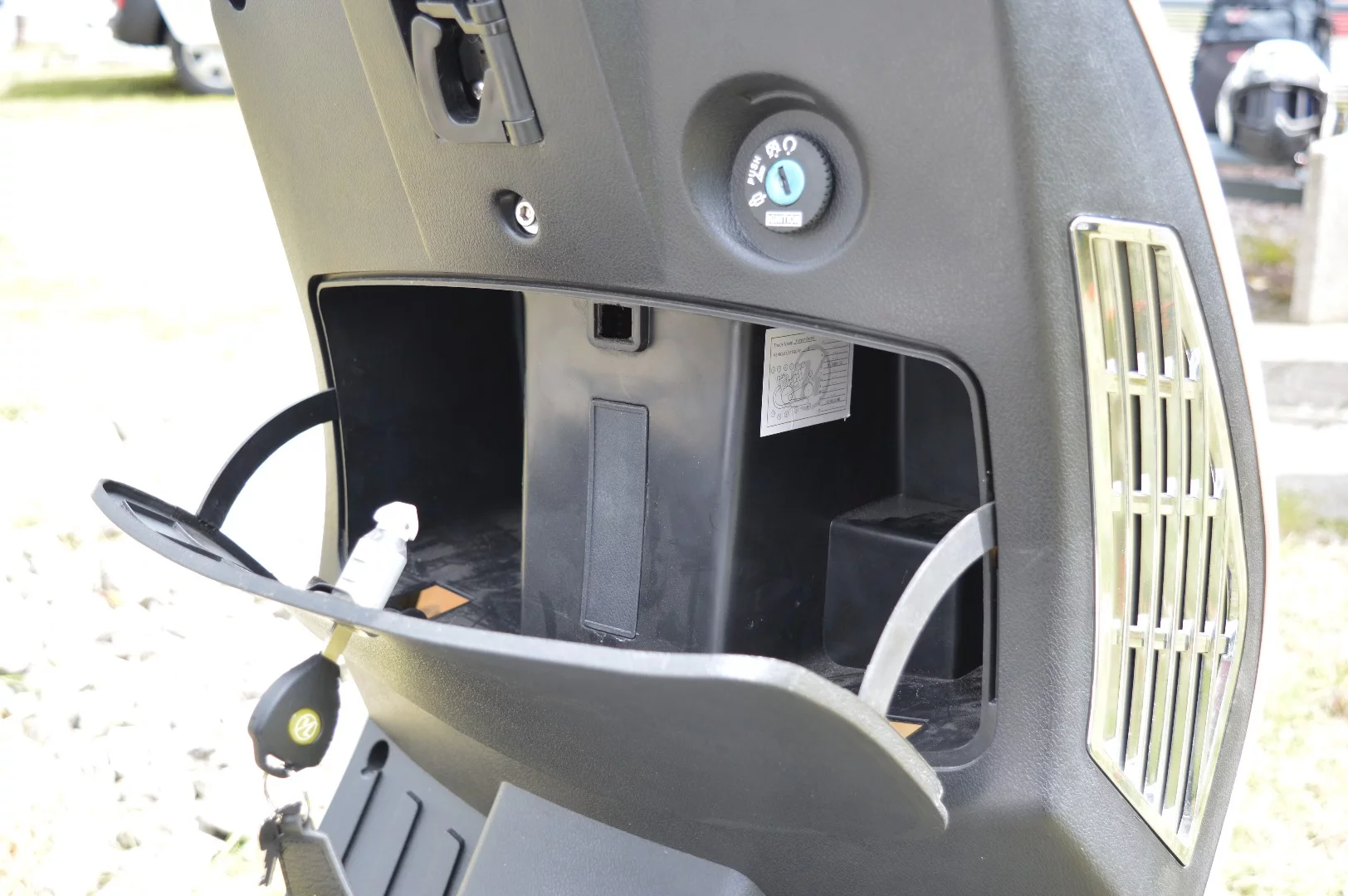 The locking compartment below the scooter's steering can hold several small items and is conveniently accessible