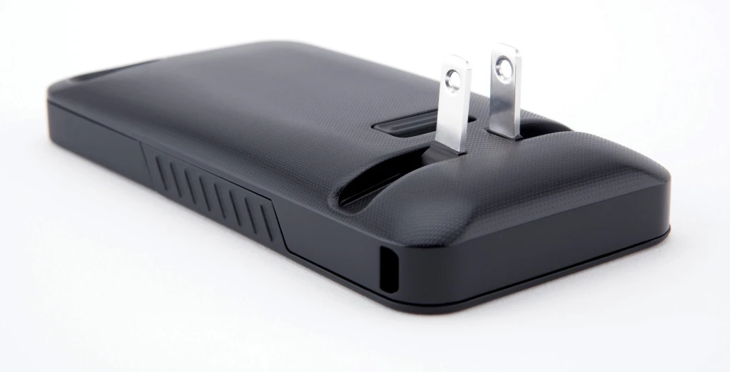 Pressing a spring-loaded button on the back of the case deploys two prongs, which come together to form a plug that will fit most electrical outlets in North America