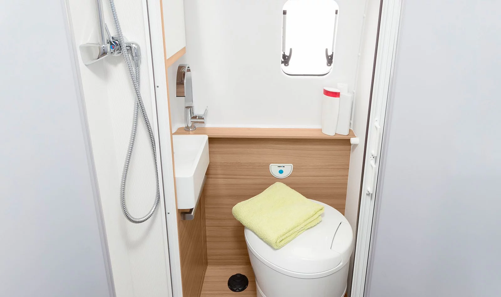 Closer look at the bathroom, which features a swiveling toilet, pull-out sink (shown in compact hand mode here), and separate shower area