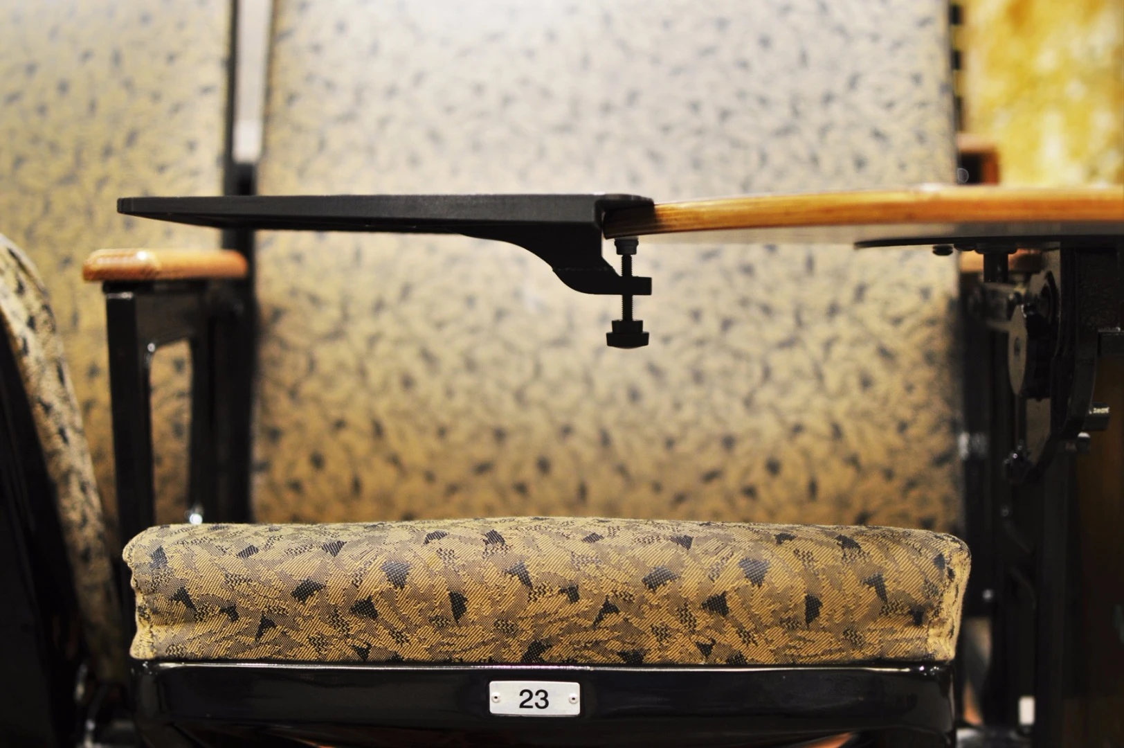 Desk Buddy connects to the fold-out arm of a lecture room chair using a clamp
