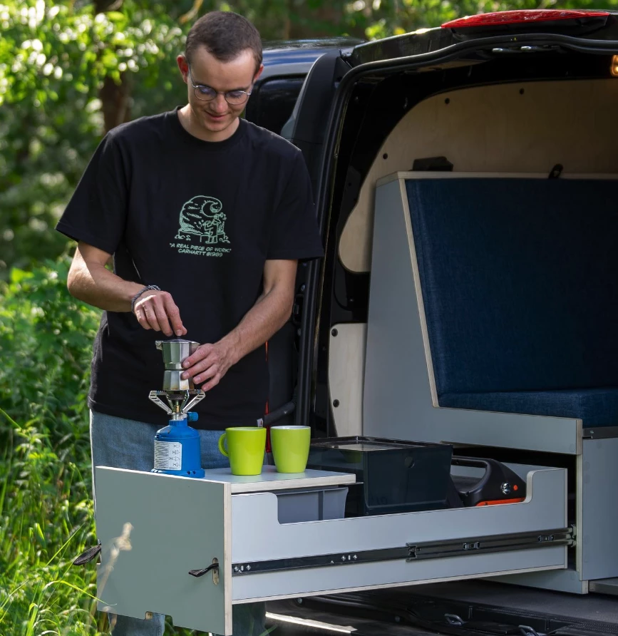 In addition to indoor kitchen area, PlugVan Small campers can use the slide-out drawer as a makeshift tailgate kitchen