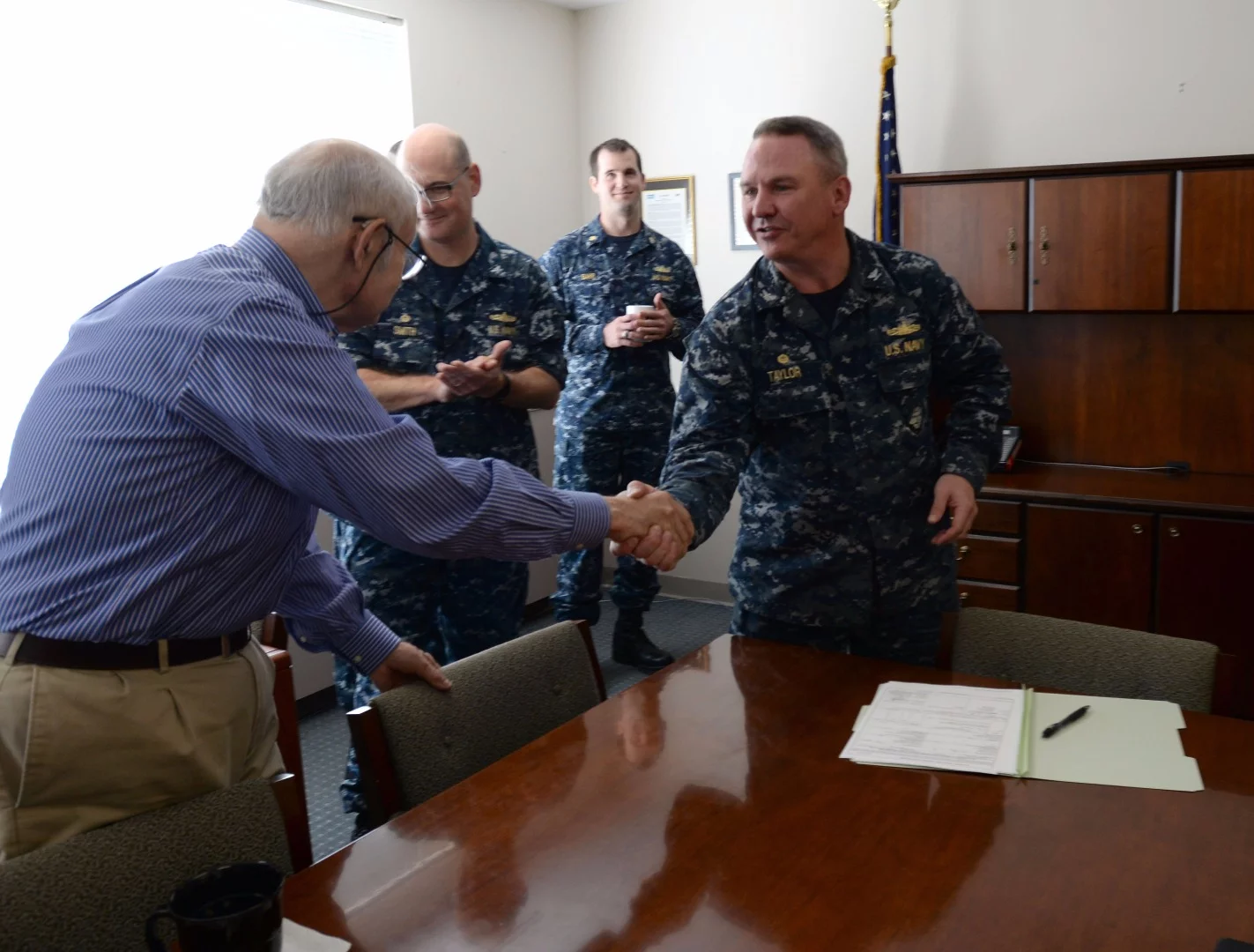 Captain Michael Taylor, commander of Supervisor of Shipbuilding in Bath, Maine, shakes hands with Fred Harris, president of Bath Iron Works