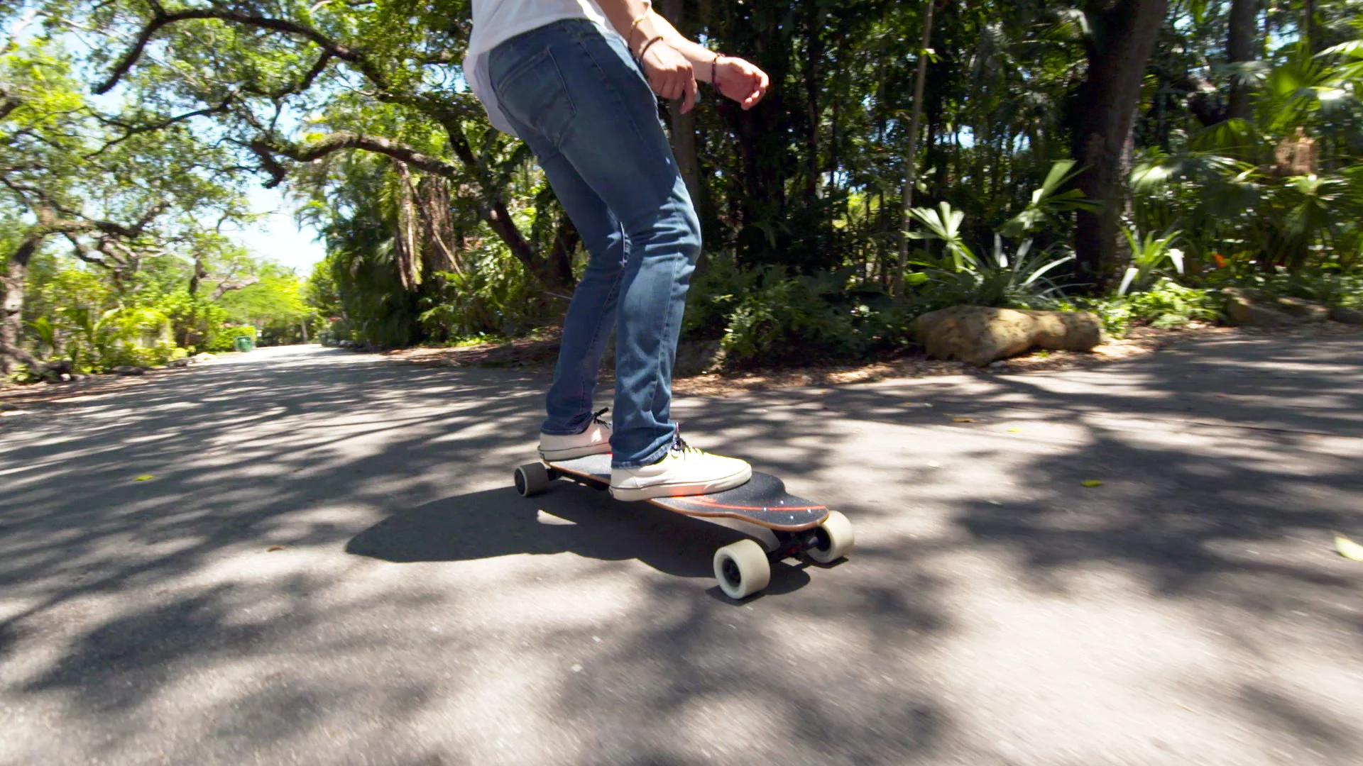 The Pomelo Pro electric longboard rider controls the speed and braking using a wireless hand remote