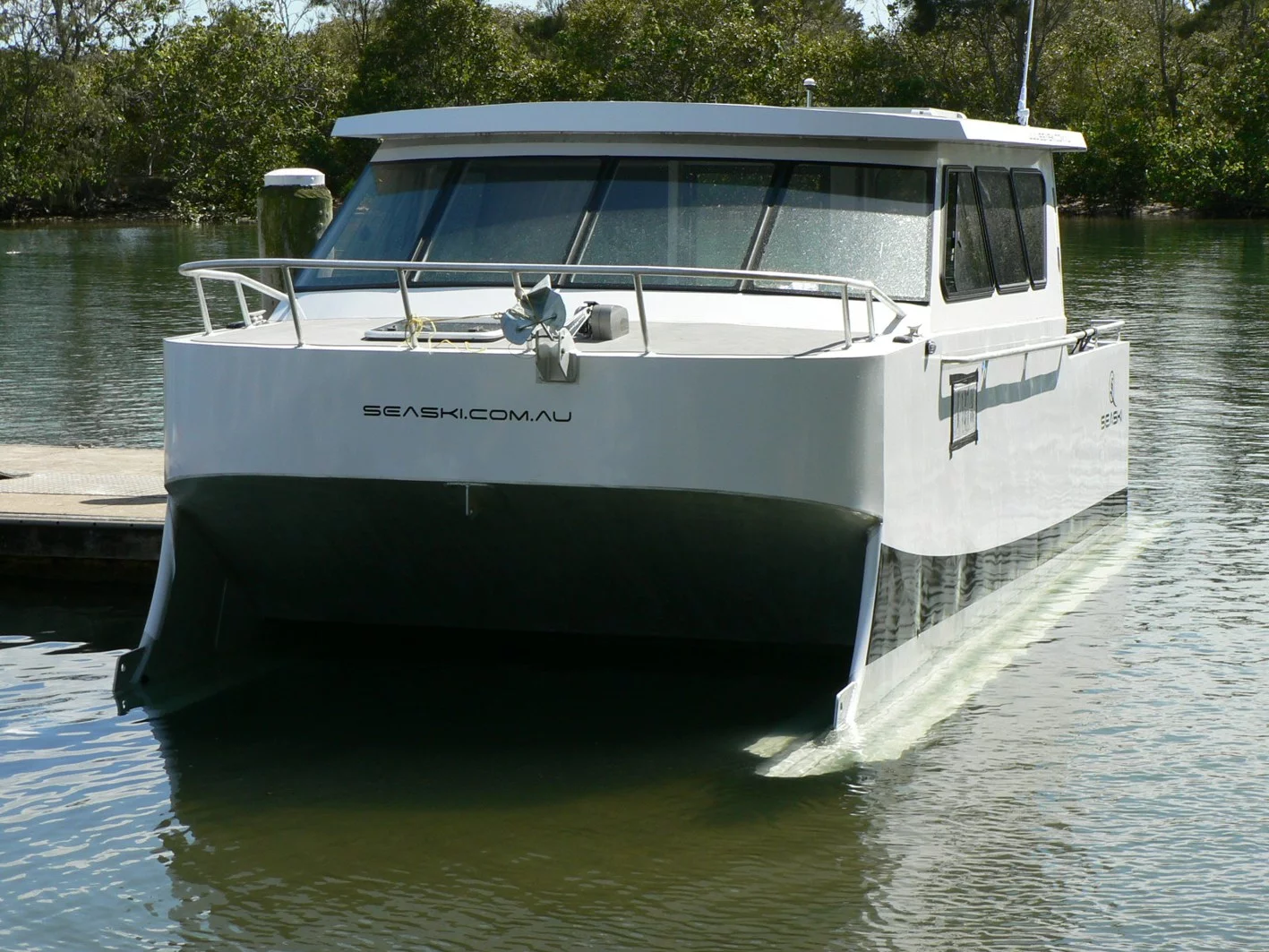 The 7-m (23-ft) vessel with its skis submerged at slow speed or moored at Fingal Boat Harbour, Northern New South Wales, Australia – it has a very wide beam at 3 m (9.8 ft)