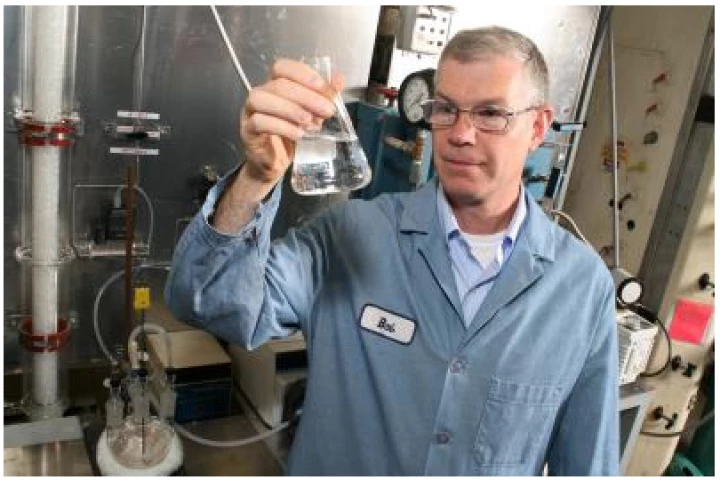 Chemist Robert Perry checks a flask containing an ingredient similar to those found in shampoos that shows promise for capturing carbon dioxide (Photo: GE Global Research)