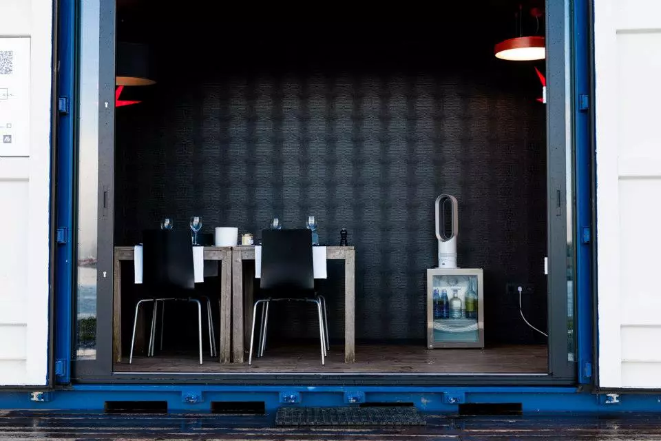 The lounge container is setup like a breakfast nook for guests to enjoy a cup of coffee or glass of wine together