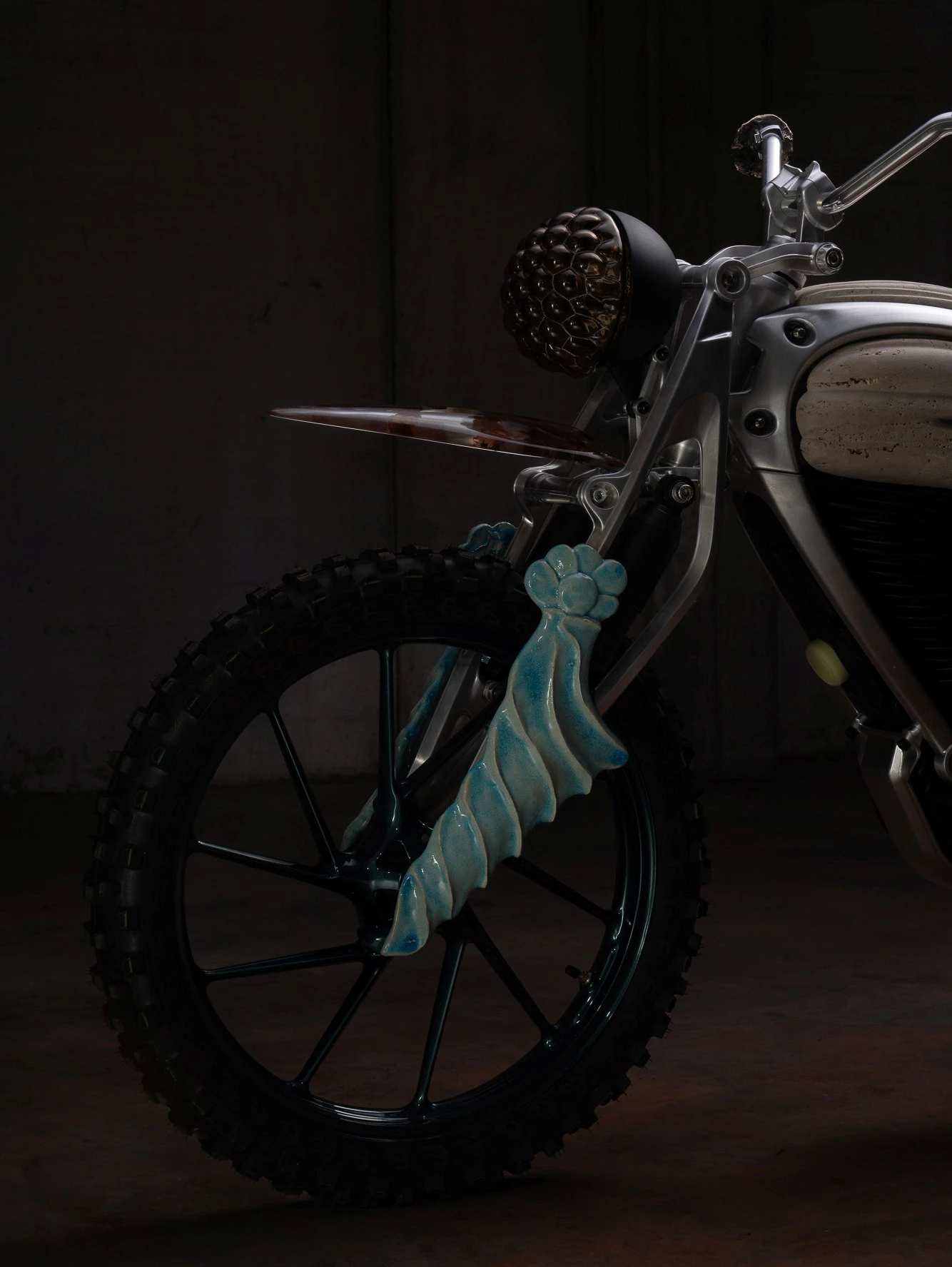 The parallelogram forks, which resemble the fork guards found on scrambler motorcycles, have hand-modeled clay details