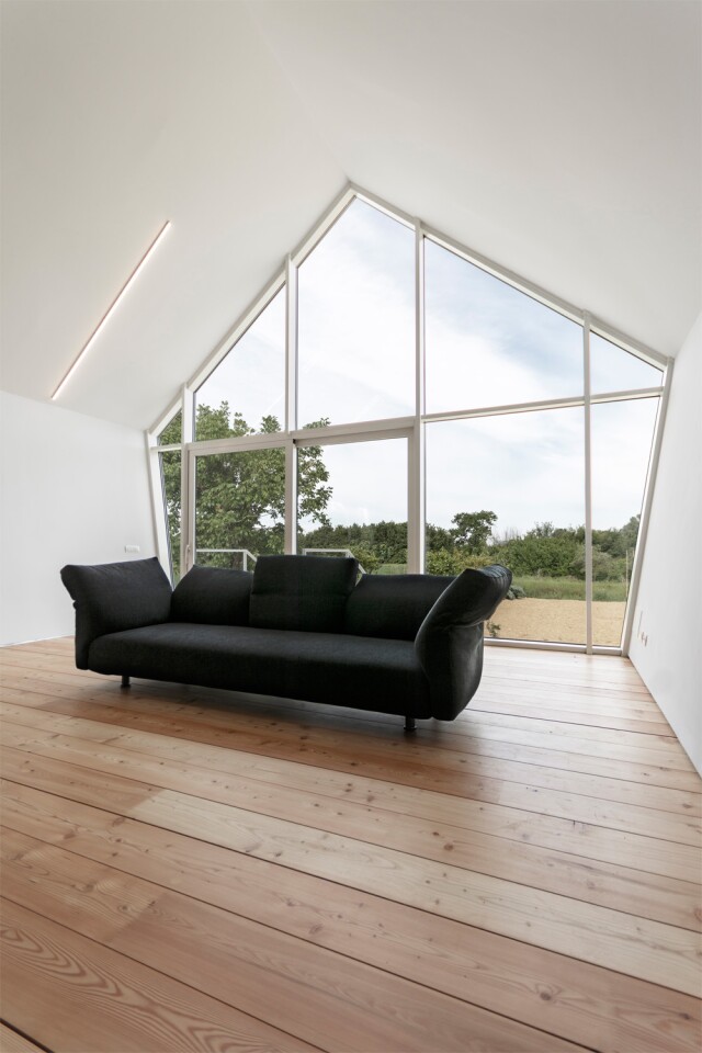 The interior design features an open lounge/living area with log fire and lovely views across the surrounding gardens