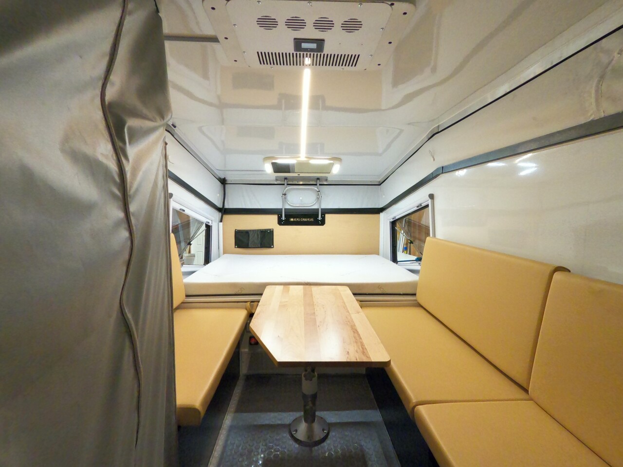 The interior is simple but functional, offering a fixed front queen bed, a convertible dinette with seating for five, and a wet bathroom with shower and cassette toilet